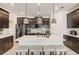 Kitchen island with seating, pendant lighting, dark cabinets, and stainless steel appliances at 1767 Bee Nice Dr, Kissimmee, FL 34744