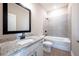 Modern bathroom with tiled shower, granite vanity, and wood-look flooring at 7849 Somersworth Dr, Kissimmee, FL 34747