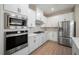 Modern kitchen featuring stainless steel appliances, white cabinetry, and light countertops at 7849 Somersworth Dr, Kissimmee, FL 34747