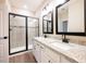 Modern bathroom with dual vanities, granite countertop, walk-in shower, and tile flooring at 7861 Somersworth Dr, Kissimmee, FL 34747