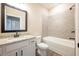 Guest bathroom with a granite-topped vanity, tiled shower/tub combo, and wood-look flooring at 7861 Somersworth Dr, Kissimmee, FL 34747