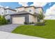 Two-story home with a paved driveway, landscaped yard, and attached garage at 7861 Somersworth Dr, Kissimmee, FL 34747