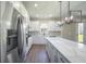 Modern kitchen featuring white cabinets, stainless steel appliances, and an island with quartz countertops at 7861 Somersworth Dr, Kissimmee, FL 34747
