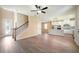 Open-concept living area with wood-look flooring, a staircase with wrought iron railing, and view of the kitchen at 7861 Somersworth Dr, Kissimmee, FL 34747