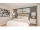 Serene main bedroom with a gray accent wall, comfortable bedding, and stylish decor at 4430 Petunia St, Lake Hamilton, FL 33851