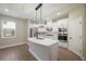 Modern kitchen featuring white cabinetry, stainless steel appliances, and a large island with quartz countertops at 7853 Somersworth Dr, Kissimmee, FL 34747