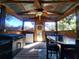 Covered screened porch with grill, table, chairs, and ceiling fan at 7598 W C 48, Bushnell, FL 33513