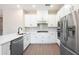 Modern kitchen featuring white shaker cabinets, stainless steel appliances, and quartz countertops at 7745 Somersworth Dr, Kissimmee, FL 34747