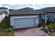 Gray house with paver driveway and landscaping; two-car garage at 4407 Rapallo Ave, Winter Haven, FL 33884