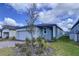 Charming one-story home with gray exterior, paver driveway, and lush landscaping at 4407 Rapallo Ave, Winter Haven, FL 33884
