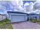Gray house with paver driveway and landscaping; two-car garage at 4407 Rapallo Ave, Winter Haven, FL 33884