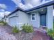 Gray exterior home with paver driveway, landscaping, and a dark gray front door at 4407 Rapallo Ave, Winter Haven, FL 33884