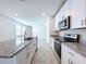 Modern kitchen with white cabinets, granite countertops, and stainless steel appliances at 4407 Rapallo Ave, Winter Haven, FL 33884
