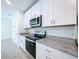 Modern kitchen with white cabinets, stainless steel appliances and granite countertops at 4407 Rapallo Ave, Winter Haven, FL 33884