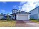 Two-story house with gray siding, beige garage door, and landscaped yard at 4936 Mainsail Street, Haines City, FL 33844