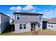 Rear view of a two-story house, showcasing a sliding glass door and a small yard at 4936 Mainsail Street, Haines City, FL 33844