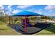 Community playground with a blue shade canopy, slides, and swings at 4936 Mainsail Street, Haines City, FL 33844