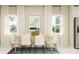 Dining area with a modern table, white chairs, and large windows at 7005 Rosy Sky Ave, Orlando, FL 32829