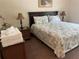Inviting main bedroom with a king-size bed, bedside tables, lamps, and wicker furniture at 409 Lucaya Loop # 409, Davenport, FL 33897