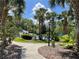 Community pool area with palm trees, a cabana, lounge chairs, and lush landscaping at 409 Lucaya Loop # 409, Davenport, FL 33897