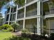 View of a condo building exterior with balconies and lush landscaping at 409 Lucaya Loop # 409, Davenport, FL 33897