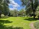 Open green space with trees, walking paths and some community amenities in the background at 409 Lucaya Loop # 409, Davenport, FL 33897