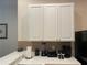 Kitchen countertop with small appliances, white cabinets, and tile backsplash at 409 Lucaya Loop # 409, Davenport, FL 33897