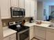 Bright kitchen featuring white cabinets, stainless steel appliances, and tile backsplash at 409 Lucaya Loop # 409, Davenport, FL 33897