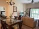 Open-concept living and dining area with a glass dining table and comfortable seating at 409 Lucaya Loop # 409, Davenport, FL 33897