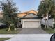 Two-story home with a light-beige exterior, two-car garage, and landscaped lawn at 1263 Verdant Glade Pl, Winter Park, FL 32792