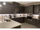 Modern kitchen with dark gray cabinets, quartz countertops, and stainless steel appliances at 1263 Verdant Glade Pl, Winter Park, FL 32792