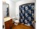 Bathroom features a shower/tub combo, wood vanity, and floral shower curtain at 4915 Mount Pleasant Rd, Groveland, FL 34736