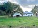 Back of house showing large oak tree and fenced yard at 4915 Mount Pleasant Rd, Groveland, FL 34736