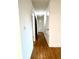 Long hallway with light walls and wood flooring at 4915 Mount Pleasant Rd, Groveland, FL 34736