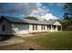 Front view of a single-story house with a garage, landscaping, and metal roof at 4915 Mount Pleasant Rd, Groveland, FL 34736