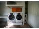 Bright laundry room with washer, dryer, cabinets, and water heater at 4915 Mount Pleasant Rd, Groveland, FL 34736