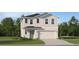 Two-story house with light beige siding, dark gray roof, and a two-car garage at 842 Hour Glass Rd, Lakeland, FL 33801