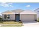 One-story house with gray siding, beige garage door, and teal front door at 1106 Foreshore Ln, Haines City, FL 33844