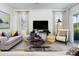 Living room with neutral colored sofas, a large TV, and sliding glass doors at 5657 Meditation Dr, Clermont, FL 34714