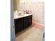 Bathroom with dark cabinets and a double vanity at 4694 Sigcom Pl, Wildwood, FL 34785