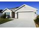 Tan house with two car garage and solar panels at 4694 Sigcom Pl, Wildwood, FL 34785