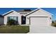 One-story home with attached garage, solar panels, and landscaped lawn at 4694 Sigcom Pl, Wildwood, FL 34785