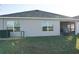 Back of house with patio and grill area at 4694 Sigcom Pl, Wildwood, FL 34785