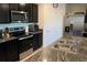 Modern kitchen with dark cabinets, granite countertops, and stainless steel appliances at 4694 Sigcom Pl, Wildwood, FL 34785