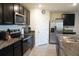 Modern kitchen with dark cabinets, granite counters and stainless steel appliances at 4694 Sigcom Pl, Wildwood, FL 34785