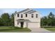 Two-story house with light beige siding, black door, and two-car garage at 830 Hour Glass Rd, Lakeland, FL 33801