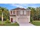 Two-story house with a two-car garage, and landscaping at 4756 Guinep Ln, Kissimmee, FL 34758