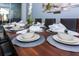 Table set for dinner with white plates and gray placemats at 1534 Carey Palm Cir, Kissimmee, FL 34747
