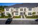 Tan, two-story townhome with gray roof, two-car driveway, and landscaping at 1534 Carey Palm Cir, Kissimmee, FL 34747