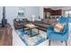 Spacious living room with gray sofas, blue armchair, and coffee table at 1534 Carey Palm Cir, Kissimmee, FL 34747